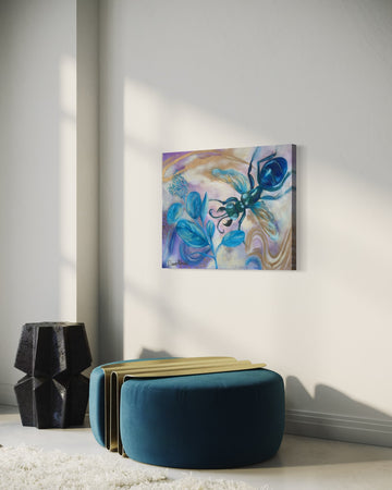 Abstract painting on a wall above a blue ottoman in a room.