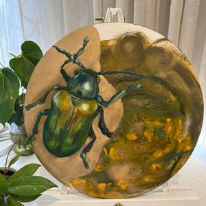 A canvas painting featuring a realistic green beetle on a circular canvas, with a background that blends into an abstract pattern of yellow and green hues.